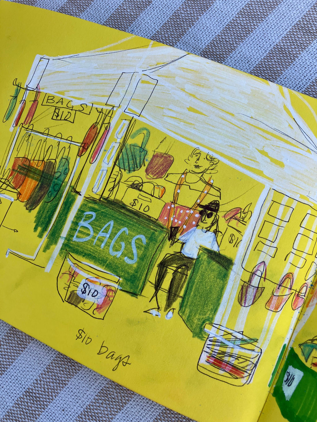 Sketchbook drawing of an art fair booth made with colored pencil and white marker on yellow paper.